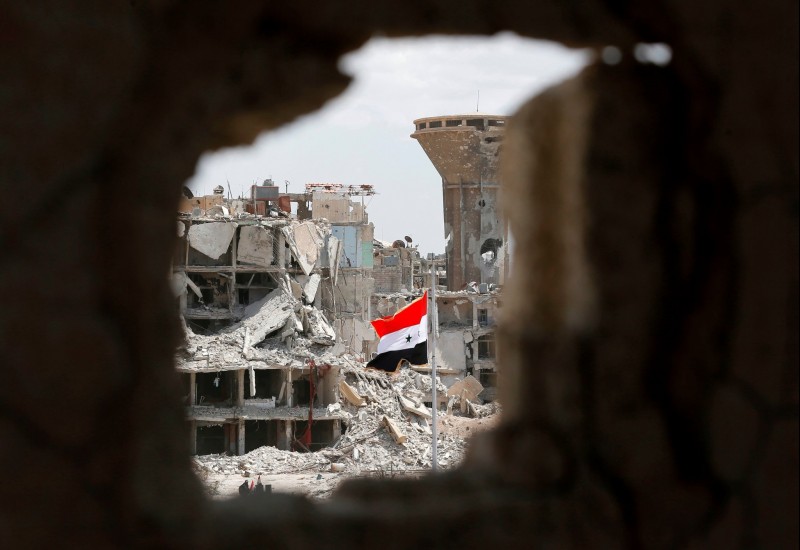 A Syrian flag flying in a rubble strewn street during a flag raising ceremony at the entrance of the Hajar al-Aswad neighborhood on the southern outskirts of the capital Damascus in May, after the regime seized the area earlier in the week from the Islamic State.CreditCreditLouai Beshara/Agence France-Presse — Getty Images