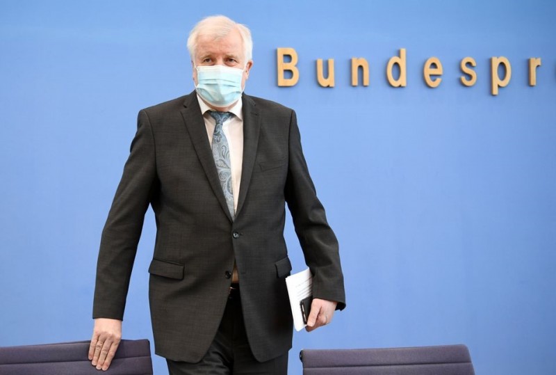 Photo: German Interior Minister Horst Seehofer takes off his mask before attending a news conference on politically motivated crimes in Germany, in Berlin, Germany May 4, 2021. REUTERS/Annegret Hilse/Pool