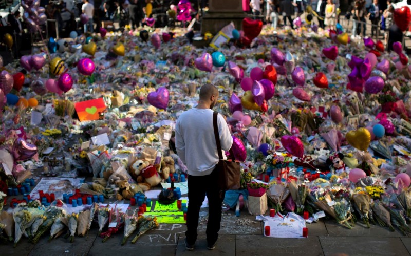  A man stands next to floral tributes for the victims of the May 2017 lone wolf terror attack at the Manchester Evening News Arena. Credit: Emilio Morenatti /AP 