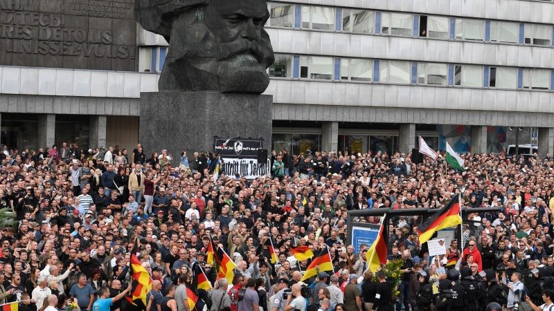 German police in riot gear patrols around the statue of Karl Marx as right wing protesters gather at the place where a man was stabbed overnight 25 August 2018, in Chemnitz, Germany, 27 August 2018. [Filip Singer/EPA/EFE]