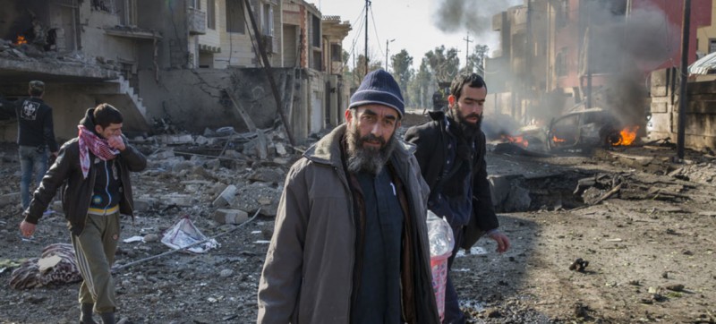 A family climbs out of their destroyed home to flee minutes after an ISIS suicide car bomber detonated his vehicle on the street outside their home in the Al Andalus neighbourhood of Mosul, Iraq (Photo: UNHCR/Ivor Prickett)
