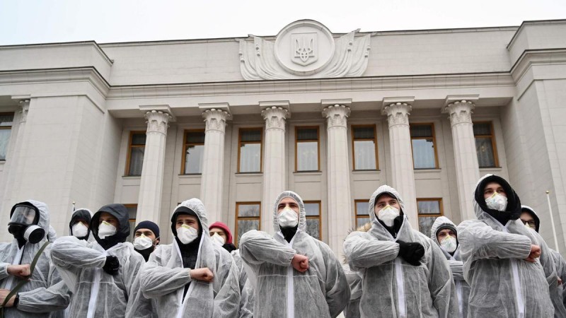 Activists of National Corps far-right party wearing gas masks and protective suits salute as they gather in front of Ukraine’s parliament. AFP